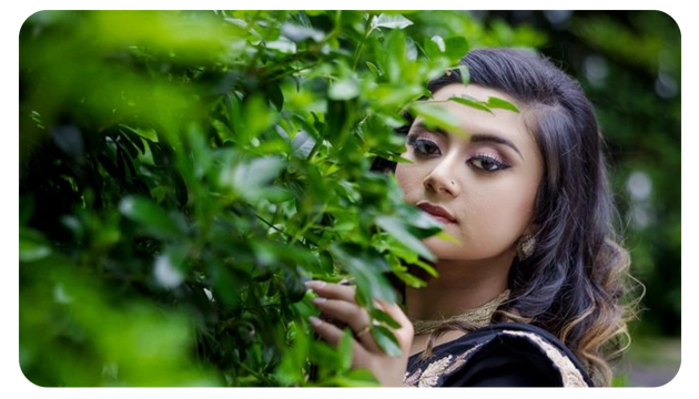 A person gently interacts with vibrant green foliage, surrounded by a lush, natural setting, showcasing a connection with nature.